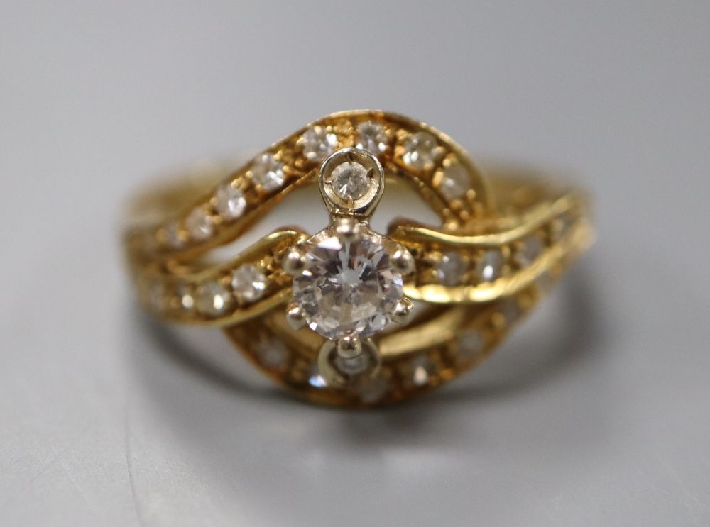 An 18ct yellow gold and diamond ring of scroll design, size O, gross 6 grams.